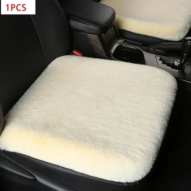A white plush rabbit fur car seat cushion is shown inside a black car seat.