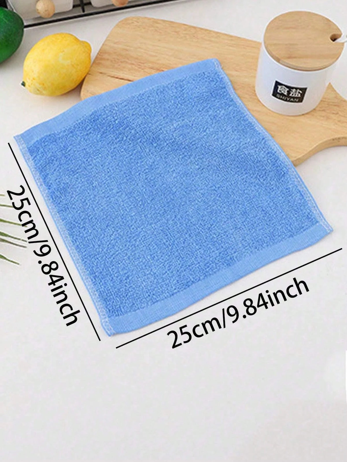 A blue microfiber cleaning cloth is shown next to a wooden board and a bamboo container.