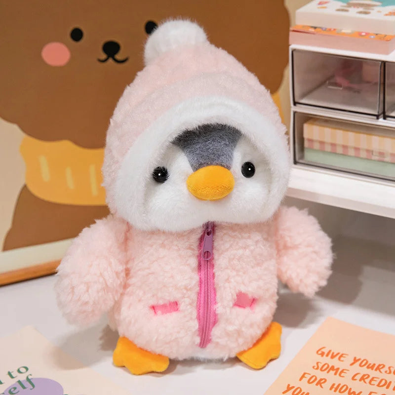 A pink penguin plush toy wearing a white hat and orange feet, displayed on a white surface.
