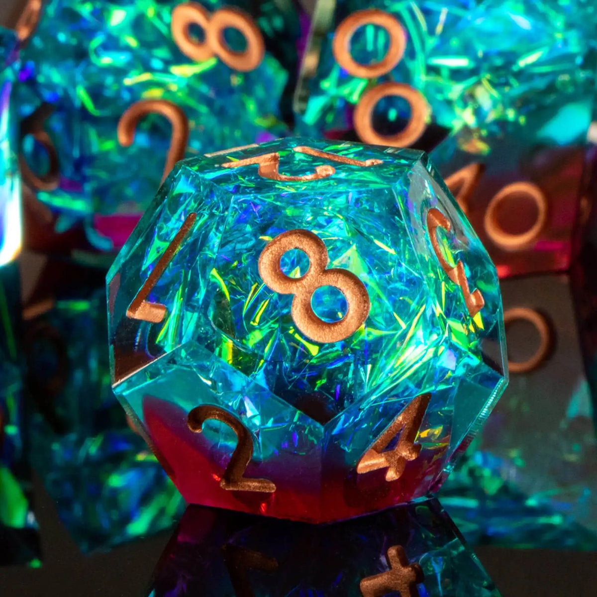 A close-up of a translucent blue polyhedral die resting on a reflective surface, surrounded by other dice.