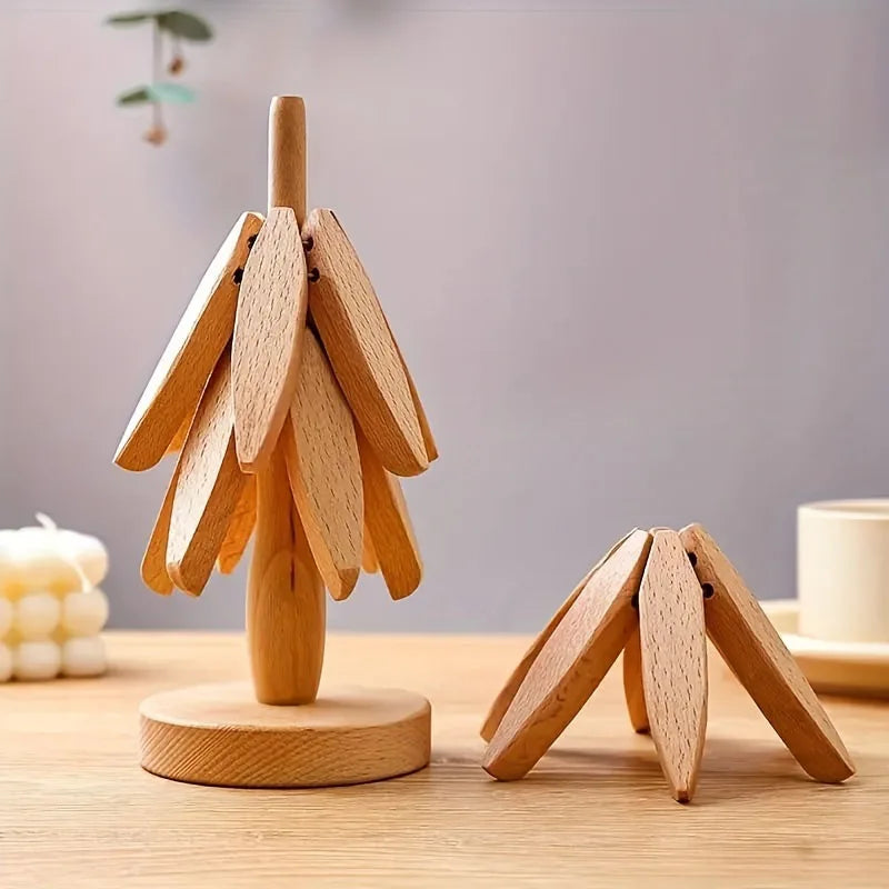A set of wooden tree-shaped heat-resistant trivets displayed on a light wooden surface.