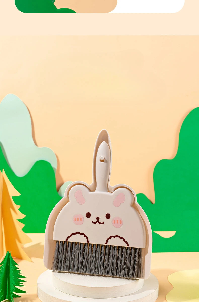A compact cartoon broom and dustpan set with a cute animal design for tabletop cleaning.