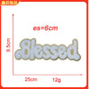 A white embroidered patch with the word Blessed on a light gray background
