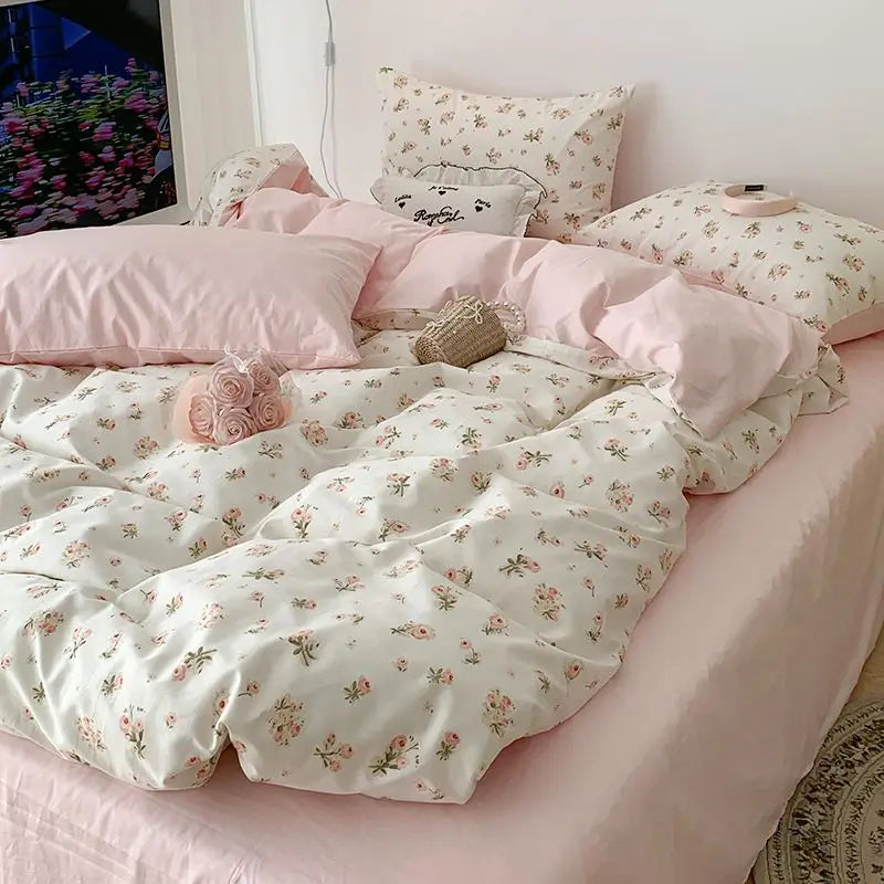 Pink floral bedding set featuring a duvet cover, pillowcases, and decorative accents on a bed.