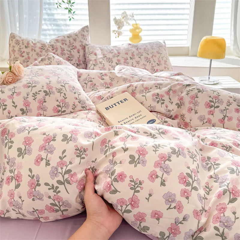 A light pink floral duvet cover set featuring a delicate pattern on a bed.