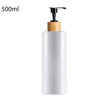 A white 500ml refillable shampoo and lotion dispenser bottle with a black pump and wooden cap.