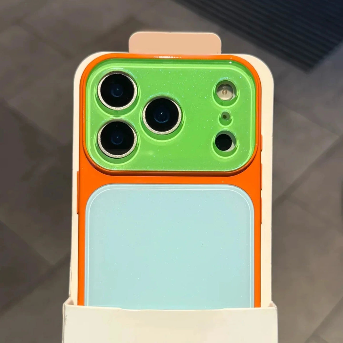 A color blocking shockproof phone case featuring a large camera window and a light blue display panel.