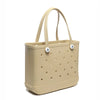 Beige tragbare EVA-Strandtasche mit perforiertem Design und hellbraunen Henkeln.