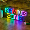 A neon sign spelling out GAMING ZONE glowing in bright colors on a wooden surface.