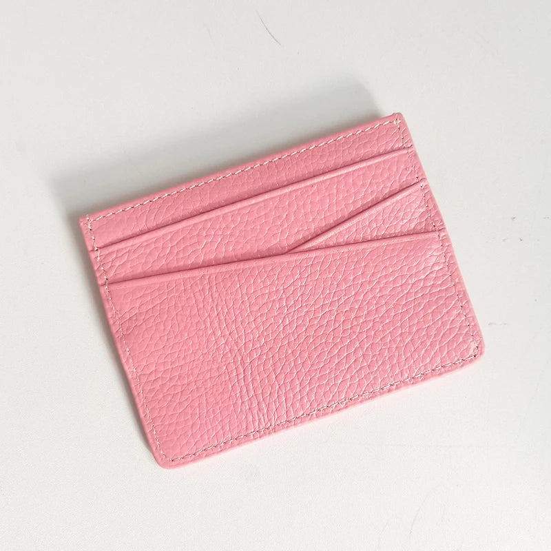 A pink genuine leather slim card holder wallet shown from above.