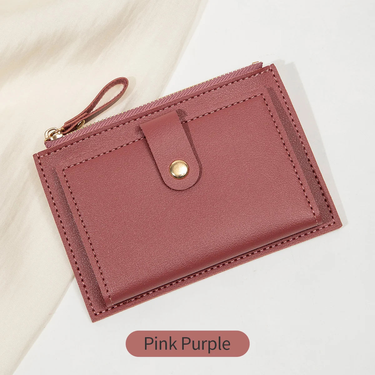 A pink purple women's slim PU leather card holder wallet with a stitched edge and leather strap.