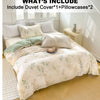 A set of elegant floral tea art print duvet cover and two pillowcases displayed on a bed.