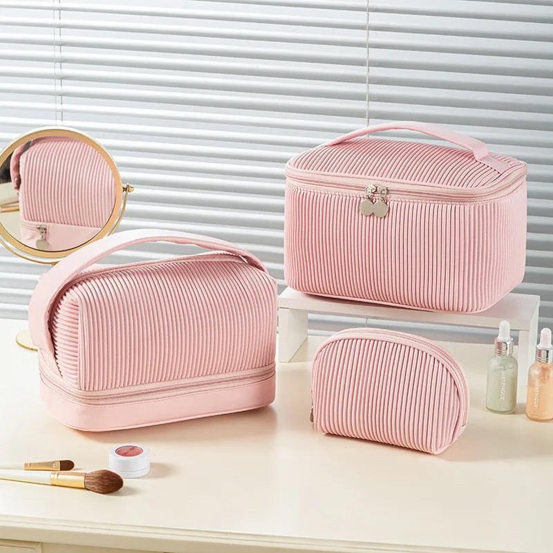 A pink ribbed PU leather makeup bag set featuring a zippered case and a separate compact case on a white surface.