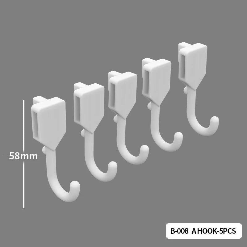 A set of five white hooks for a desktop pegboard organizer, shown with a scale marker.