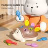 A white hedgehog puzzle toy with orange ears and various colored pegs is shown on a wooden surface.