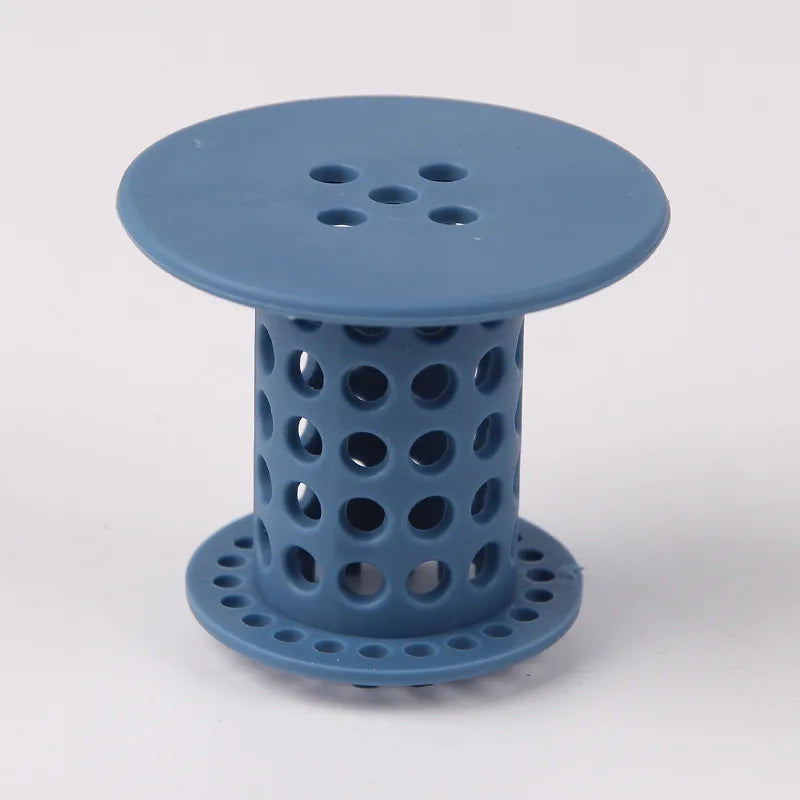 A light blue flexible hair catcher drain cover with a perforated top and cylindrical body.