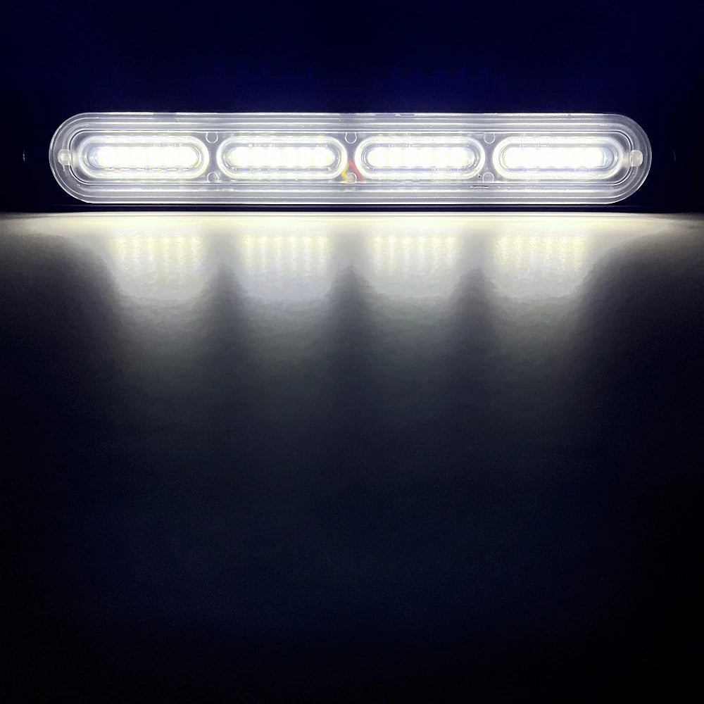A bright white LED strobe warning light bar illuminates a dark surface.