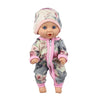 A baby doll wearing a floral print jumpsuit and matching hat.