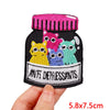 A black embroidery patch featuring cartoon cats in various colors, including pink, yellow, purple, and green.