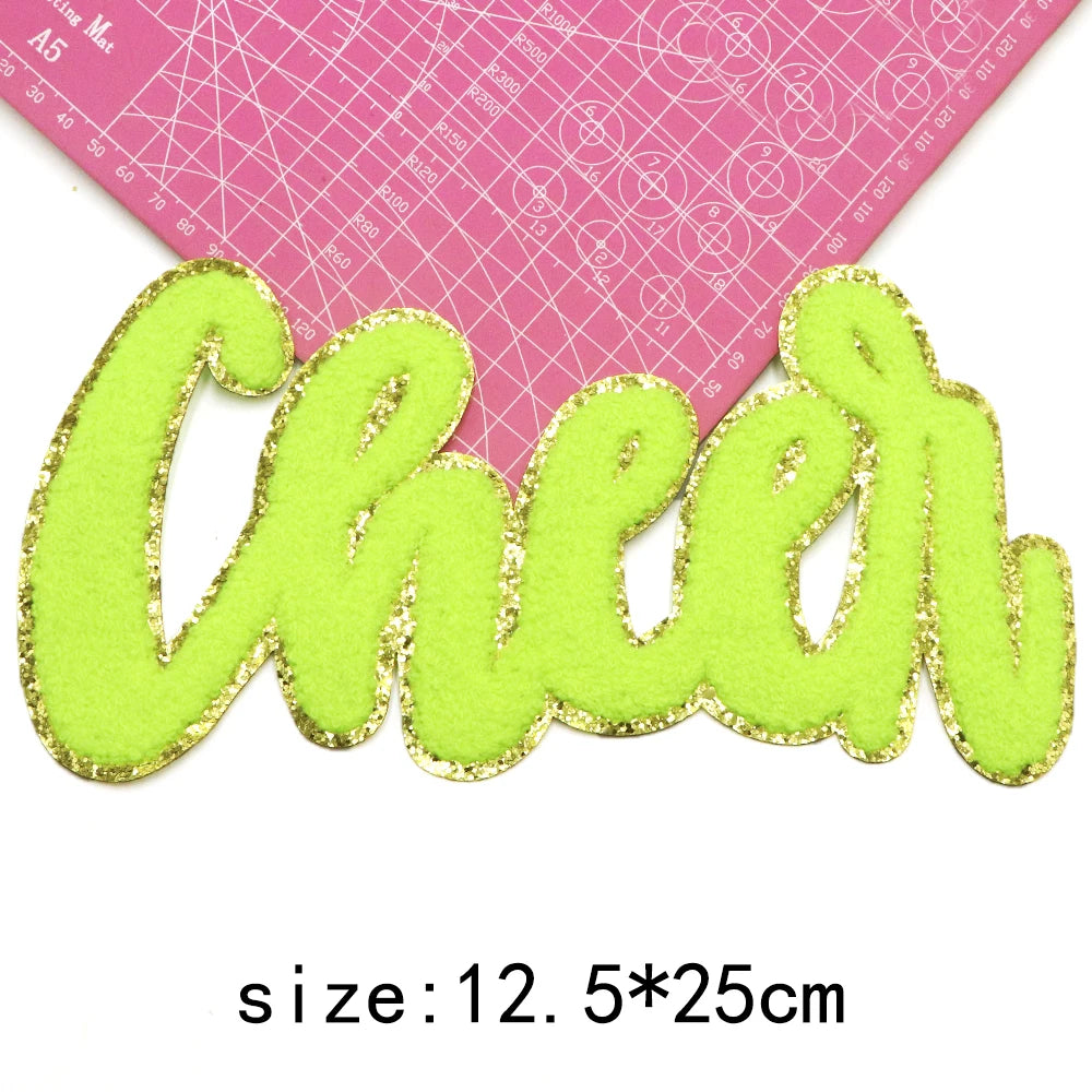 Lime green chenille letter patch spelling Cheer on a pink ruler background