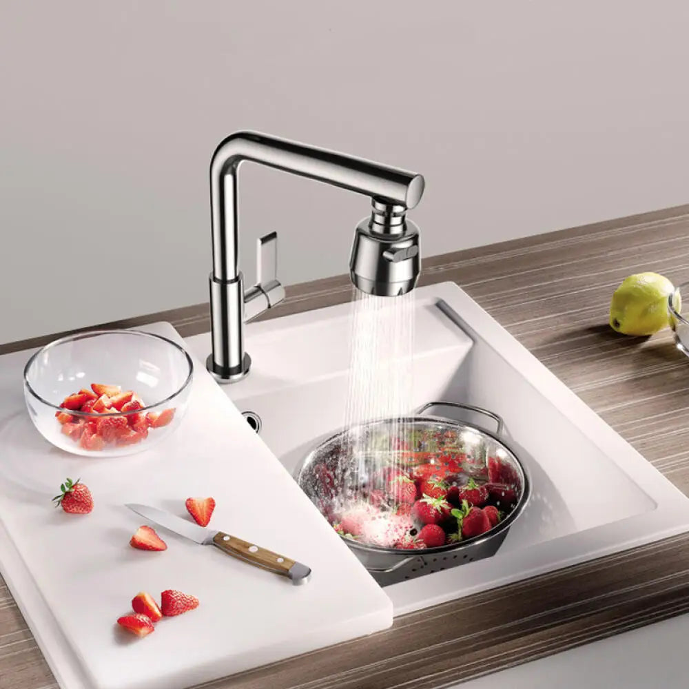 A modern kitchen faucet is shown dispensing water into a pot of strawberries in a white sink.
