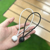 A hand holds two white and black elastic tent tie-down ropes with plastic buckles.