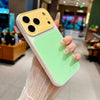 A hand holds a color blocking shockproof phone case with a large camera window, featuring yellow and light green sections.
