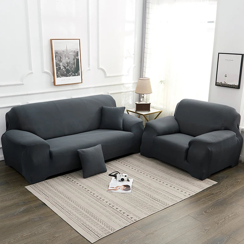 A dark gray silky soft stretchable sofa cover for pet owners displayed on a modern living room floor.