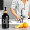 Black bamboo pump dispenser bottle next to a kitchen sink with an orange visible.