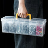 A hand holds a clear plastic multi-compartment tool organizer storage box with yellow handles.