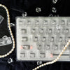 Translucent PC keycaps for mechanical keyboards displayed on a black surface with scattered ice shards.