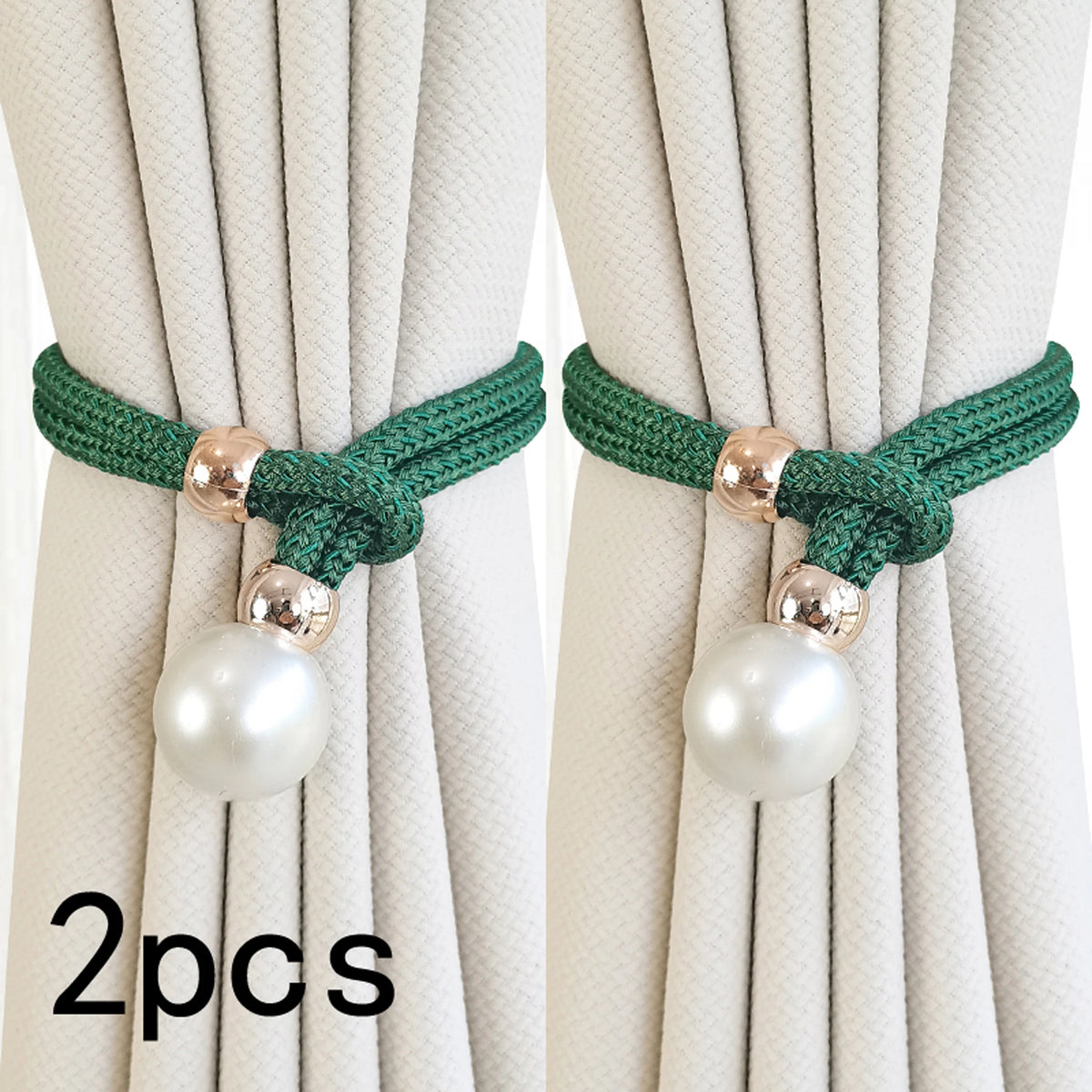A pair of green rope curtain tie-backs with pearl accents against a light beige curtain.