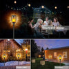 Outdoor lighting featuring solar flame torch lights decorating a garden and pathway during a snowy night.