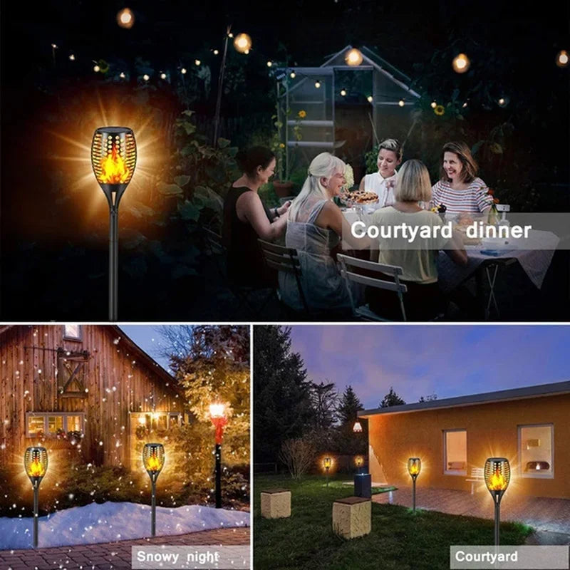 Outdoor lighting featuring solar flame torch lights decorating a garden and pathway during a snowy night.