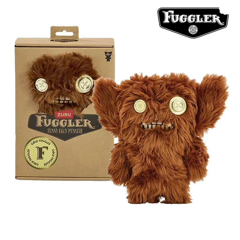 A brown, fuzzy Fuggler Ugly Monster plush toy with gold eyes and funny teeth displayed next to its packaging.