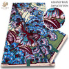 A bolt of pink glitter African wax print fabric featuring blue, purple, and green floral patterns.