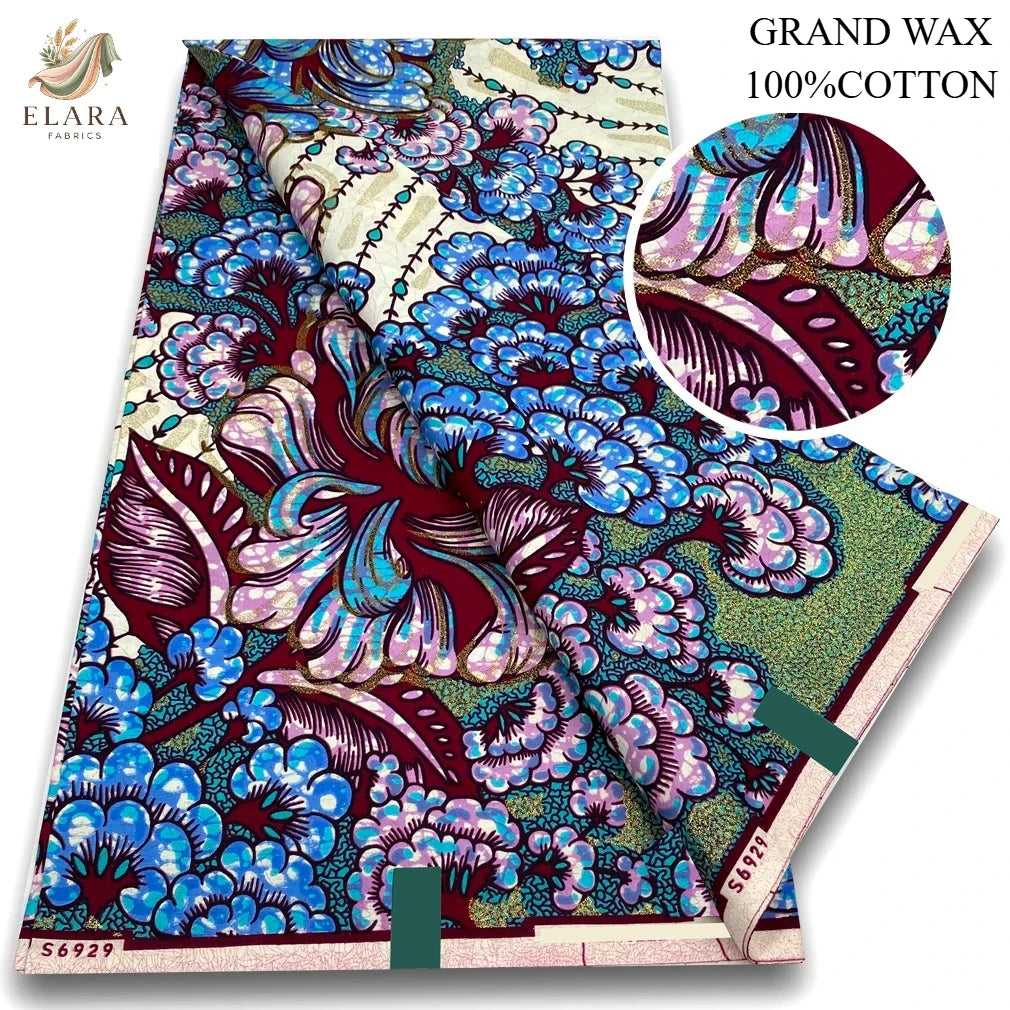 A bolt of pink glitter African wax print fabric featuring blue, purple, and green floral patterns.