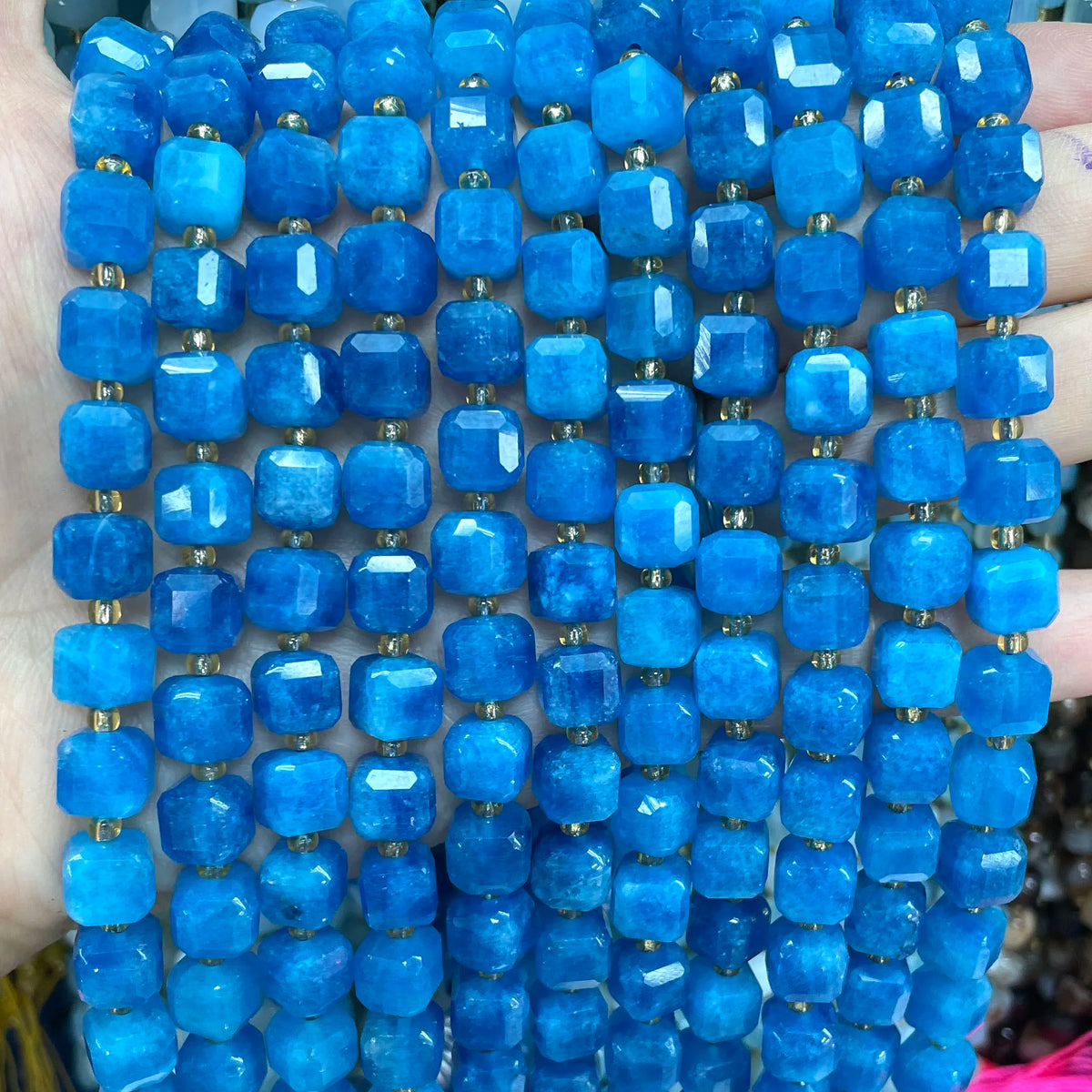 A close-up of strands of bright blue natural stone square faceted beads for jewelry making