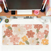 A pink and orange floral mouse pad with various flower shapes for office or gaming use.