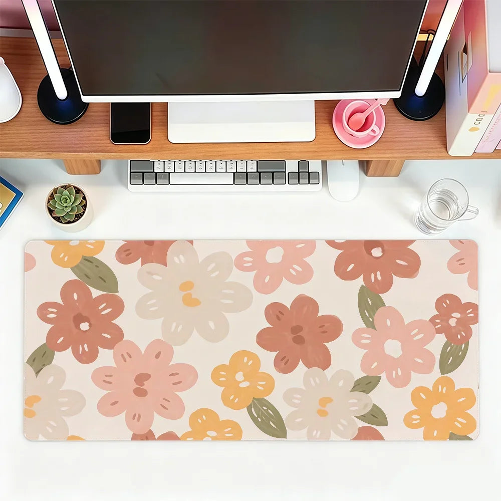A pink and orange floral mouse pad with various flower shapes for office or gaming use.