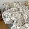 A set of soft printed duvet covers and pillowcases featuring a gray and white floral pattern.