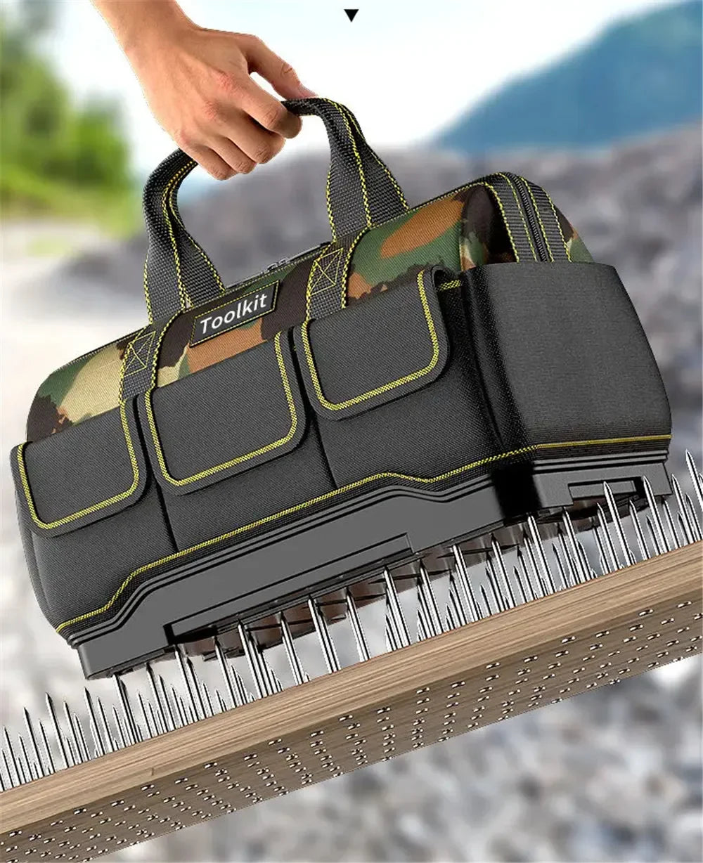 A hand is holding a heavy-duty camouflage tool bag with a reinforced base, shown resting on a wooden surface.