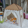 A beige teepee play tent with a brown roof and floral patterned fabric inside.