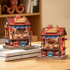 A detailed miniature kit of a Japanese book nook featuring a traditional building with lighting elements.