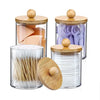 Clear acrylic apothecary jars with wooden lids filled with various toothbrushes