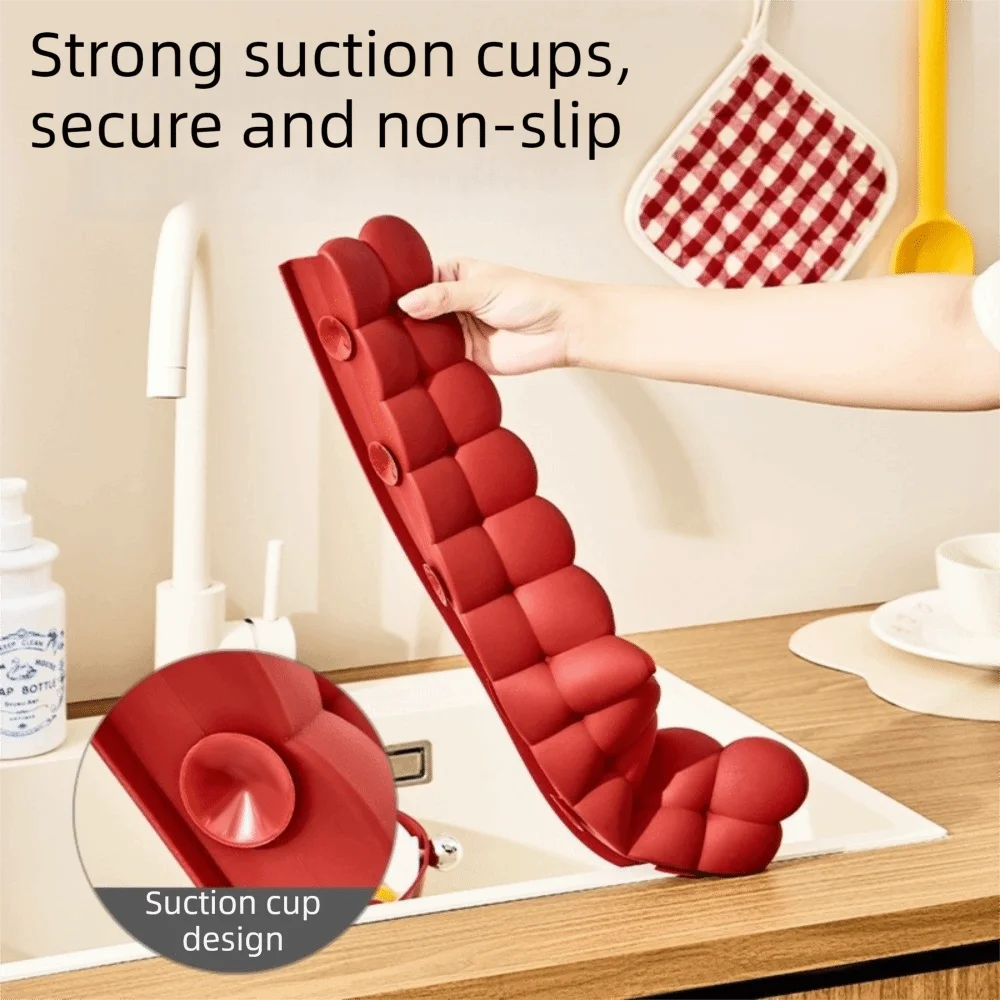 Roter Silikon-Spülschutzabfluss mit Saugnapf-Design in einer Küchenspüle in Gebrauch.