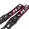 Black strap with pink floral print and JDM text, featuring a metal clasp.