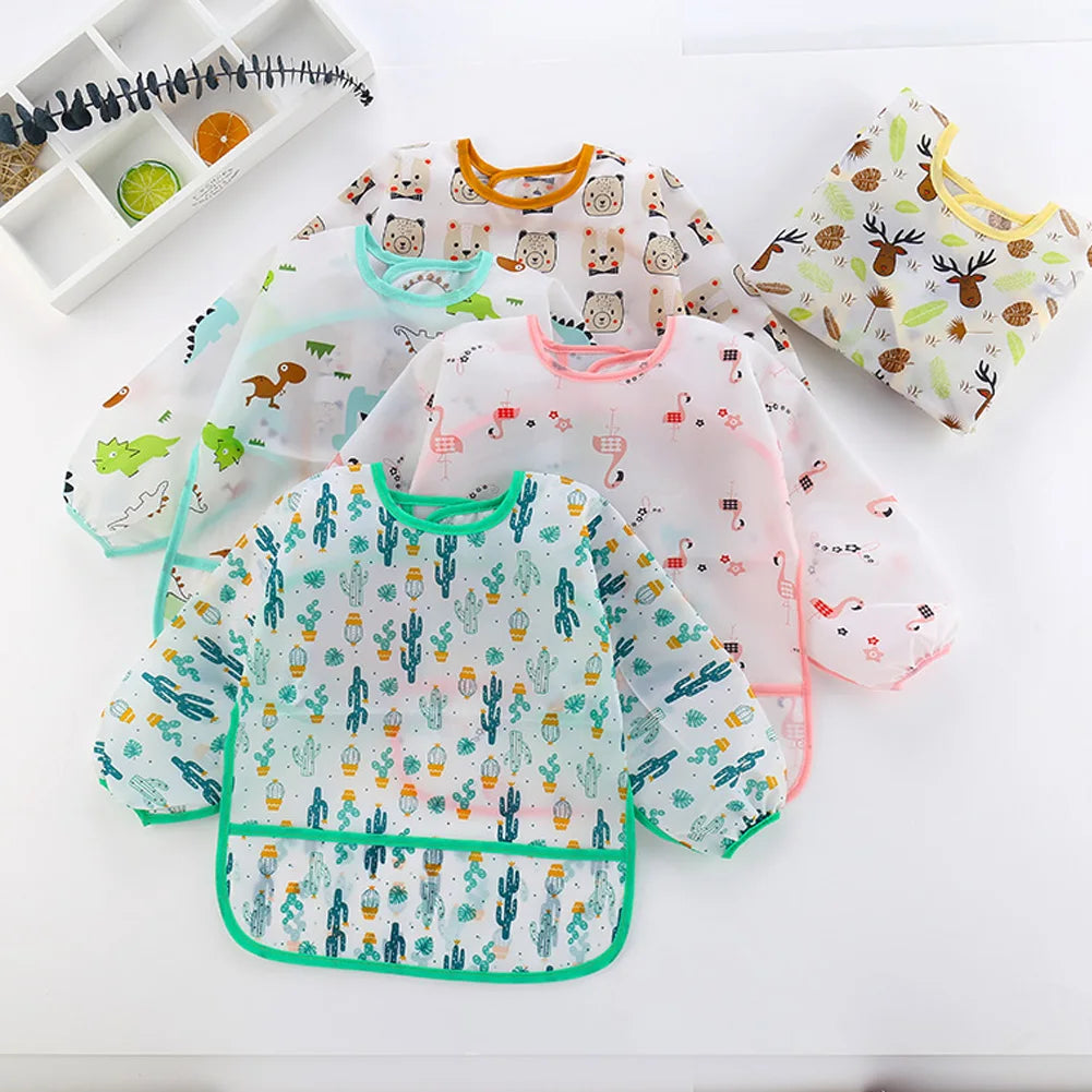 A white kids waterproof long sleeve art smock and feeding bib featuring various cute animal patterns.