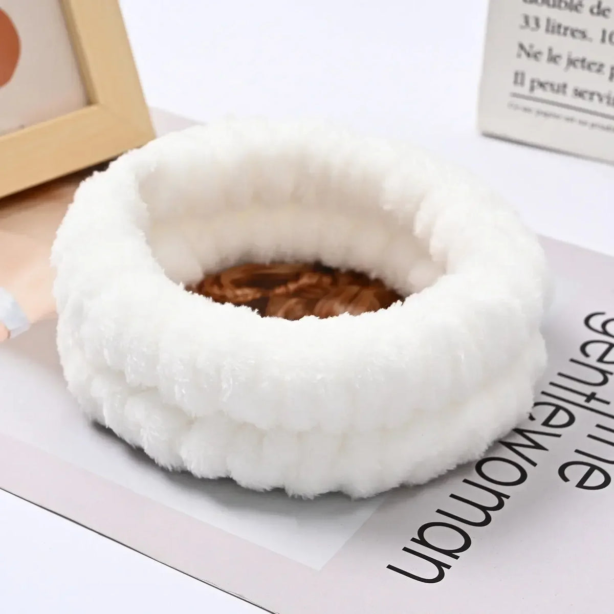 A white microfiber wrist sweatband and scrunchies for face washing are shown on a light surface.