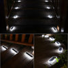 A set of solar powered LED step and path lights illuminating a wooden staircase and pathway at night.